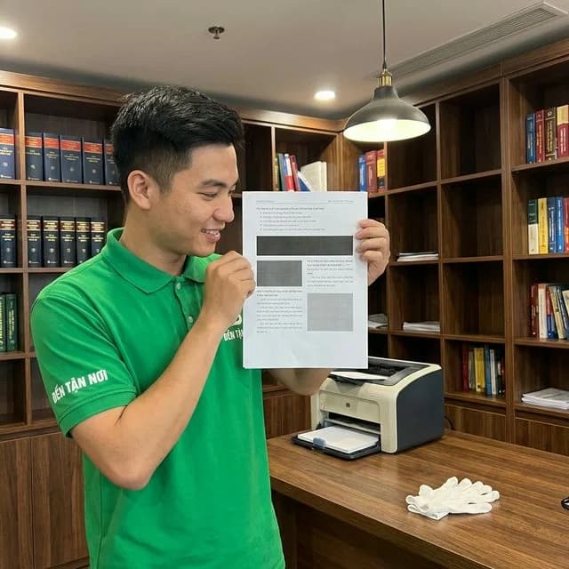 Kỹ thuật viên ĐẾN TẬN NƠI cầm tờ in thử kiểm tra chất lượng bản in tại nhà ở khu tái định cư ở quận Hòa Vang